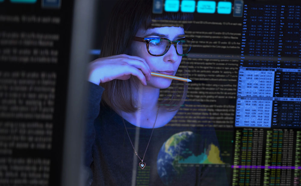 Audit et conseil Une femme regarde des écritures sur son écran. Elle est concentrée, en pleine réflexion.