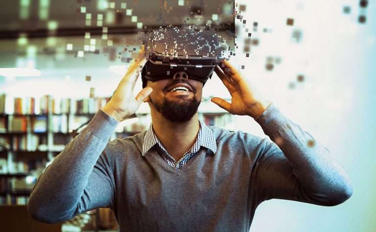 Un homme souriant porte un casque de réalité virtuelle.