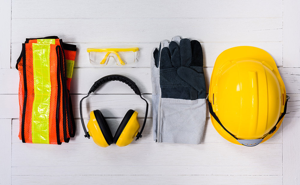 Photo avec des équipements de protection : gilet jaune, casque, gants, lunettes et casque pour les oreilles.