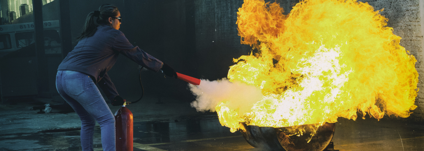 Formation incendie code du travail femme avec un extincteur combattant le feu