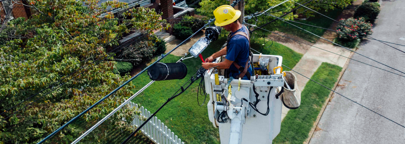 homme travaillant en hauteur avec des cables électriques