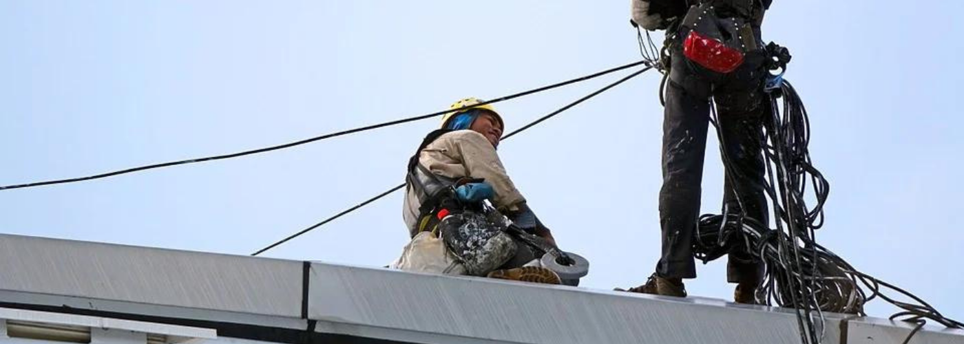 deux hommes travaillant en hauteur avec casques et harnais