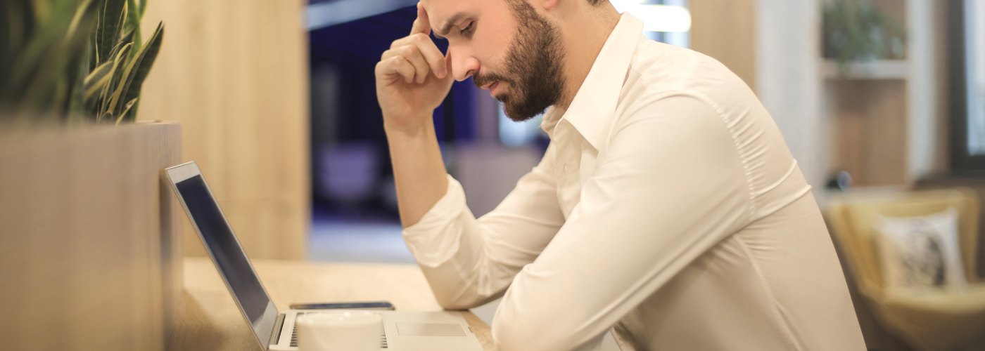 homme courbé devant son ordinateur