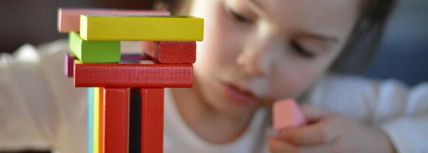 petite fille jouant avec des constructions de bois